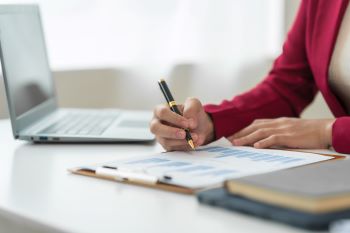 Goal Staffing Solutions Accounting specialist analyzing financial data and signing reports