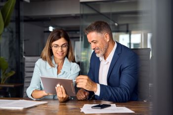 Goal Staffing Solutions professionals discussing staffing strategies on a tablet
