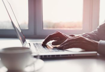 Goal Staffing Solutions professional working on staffing and payroll tasks on a laptop