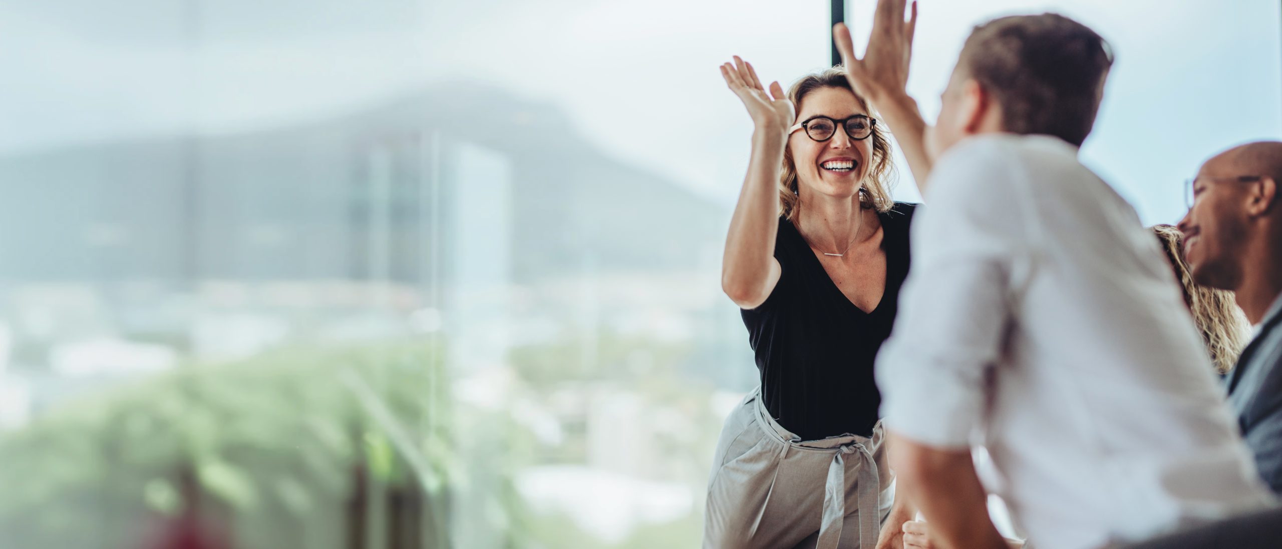 Businesswoman,Giving,A,High,Five,To,Male,Colleague,In,Meeting.